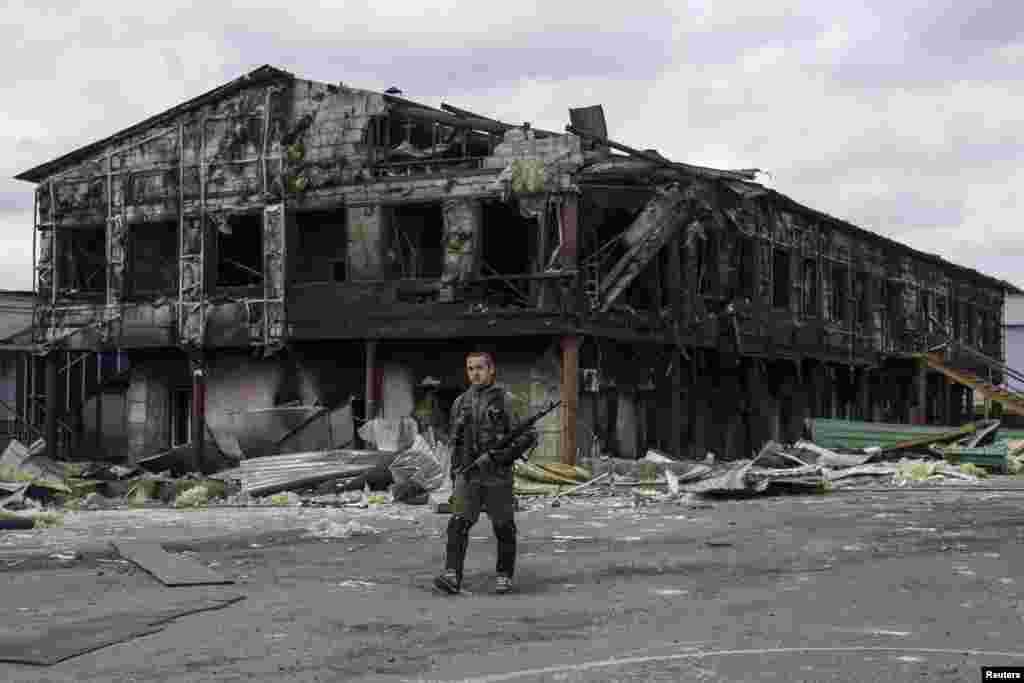 A pro-Russian rebel walks in front of a factory destroyed during recent shelling&nbsp;in the eastern Ukrainian town of Nizhnaya Krinka. (Reuters/Marko Djurica) 