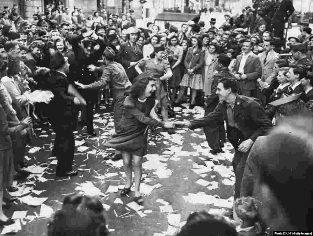 Британки танцуют с американскими военными в Лондоне 8 мая 1945 года после капитуляции Германии