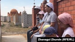 Аманбай Арзығұлов пен бала-шағасы Covid-19 індеті кезінде қайтыс болған туыстарына бейіт басында құран бағыштап отыр. Ақтөбе, 7 тамыз 2020 жыл.