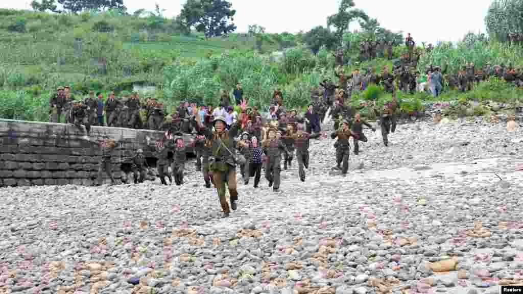 Soldiers and residents run to greet North Korean leader Kim Jong Un as he arrives to visit a military unit on an island southwest of Pyongyang. (REUTERS/KCNA)