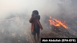 Ýangyndan goranýan çaga. Dhaka, 2012 ý.