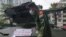 Войник пред бронетранспортьор, на който протестиращи са поставили надпис "Не искаме военно правителство"