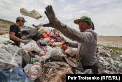Тұрмыс қалдығын төгетін күресінде жұмыс істеп жүрген адамдар. Алматы облысы, 22 маусым 2021 жыл.