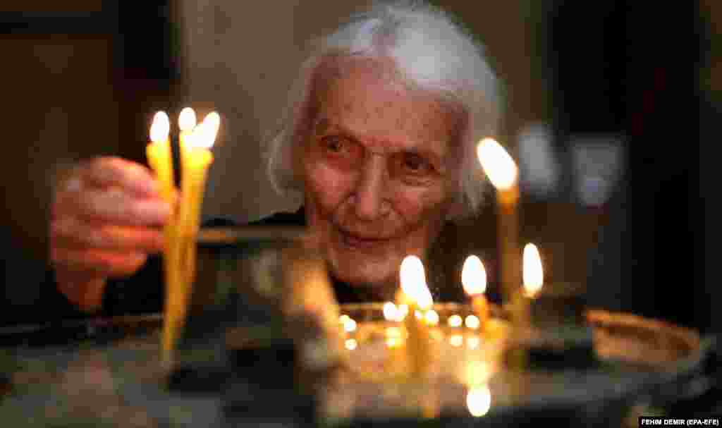 Hrišćanka pali svijeće tokom vaskršnje službe u pravoslavnoj crkvi u Sarajevu.
