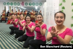 Обитательницы «образовательного центра» в Хотане танцуют для делегации иностранных журналистов, Синьцзян, 5 января 2019 года.