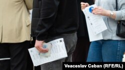 Persoane așteptând să voteze, într-o secție de vot din Republica Moldova.