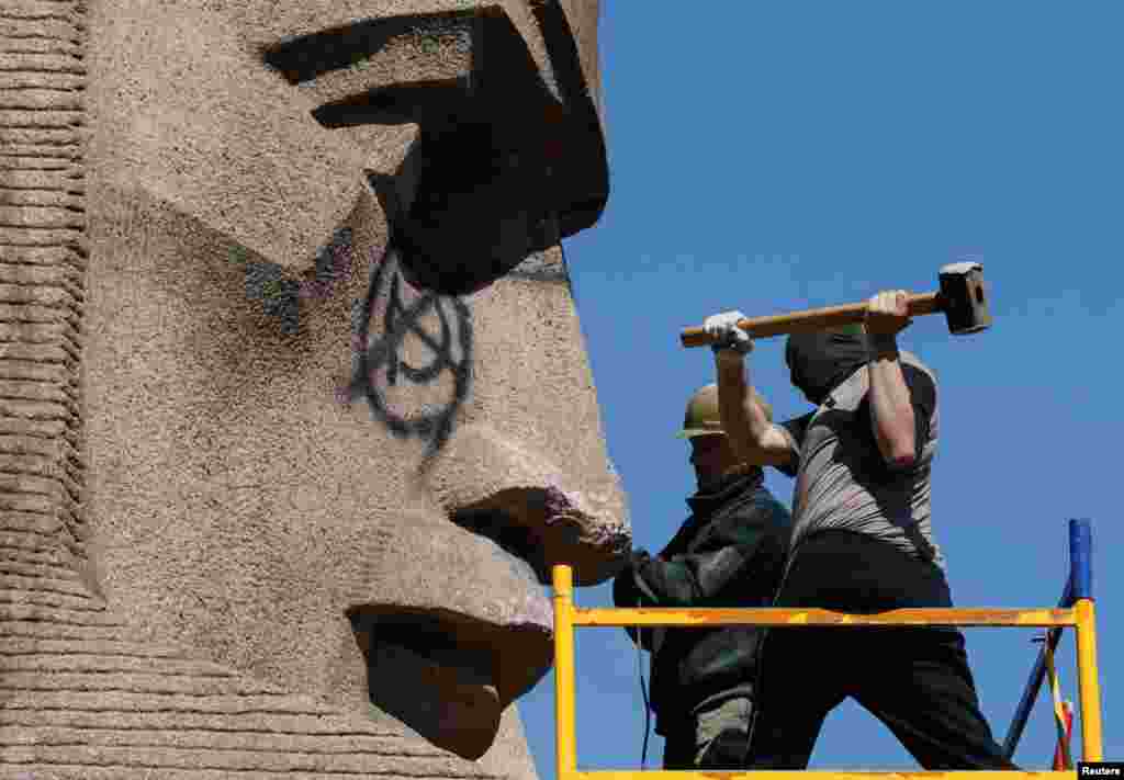 Activists of far-right and nationalist groups attempt to damage a monument to Soviet "chekists," officers of a Soviet state security organization, in Kyiv on April 28. (Reuters/Valentyn Ogirenko)