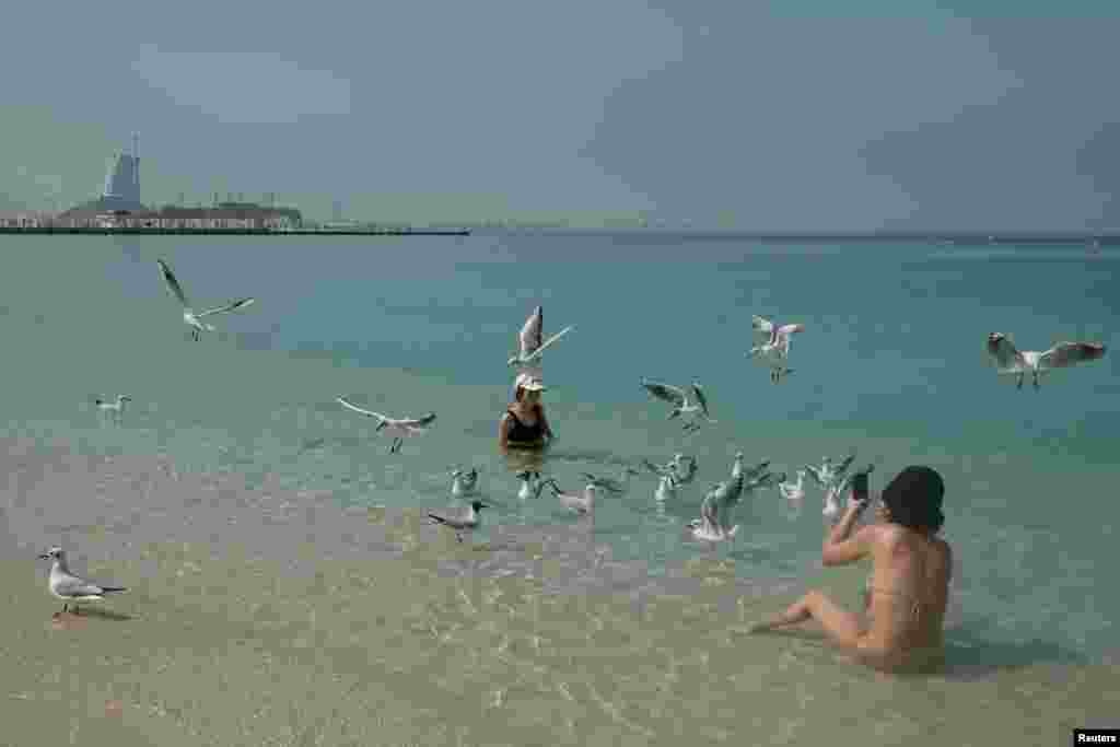 Люди отдыхают на пляже Кайт-Бич на фоне отеля Burj Al Arab после иранского нападения, последовавшего за ударами США и Израиля по Ирану, в Дубае, Объединенные Арабские Эмираты, 1 марта 2026 года. REUTERS/Amr Alfiky