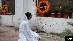 یوه عیسايي مېرمن د پېښور کلیسا کې د وژل شویو خپلوانو په غم کې ویر کوي. ۲۴ سیپټېمبر ۲۰۱۳