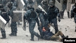 22 січня 2014 року. Бійці «Беркуту» тягнуть побитого учасника акцій на Майдані у Києві, які увійшли в історію як Революція гідності. 