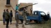 A rebel fighter from the Ahrar al-Sham Islamist movement gestures while standing on a pick-up truck mounted with an antiaircraft weapon, as he looks at the sky with his fellow fighters outside Idlib.