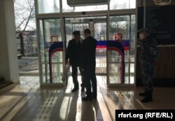 Un agent de pază măsoară temperatura vizitatorilor într-un supermarket Sheriff la Tiraspol, în plină epidemie de coronavirus.