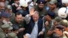 FILE: Police escort jailed former Pakistani prime minister Nawaz Sharif (C) as he leaves the accountability court in Lahore in October 2019.