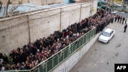 Tährandaky az girdejili eýranlylar hökümet tarapyndan berilýän kömekleri almak üçin hatara düzülipdirler. 3-nji fewral, 2014 ý.