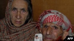 Pakistani Kashmir parents of convicted killer Shafqat Hussain, display a photograph of their son, in Muzaffarabad on March 12. 