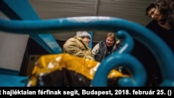 Az otthontalanokat segítő Menhely Alapítvány munkatársa egy hajléktalannak segít, Budapest, 2018. február 25. (MTI/Balogh Zoltán)