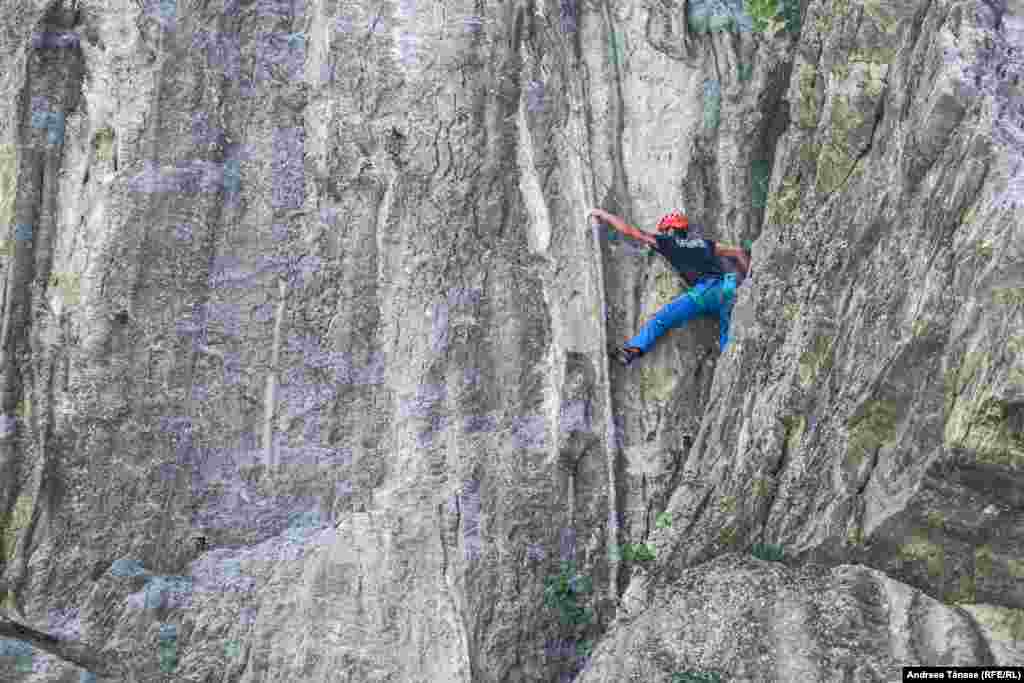 Florin Ana, sportiv și instructor la Climb Again, escaladează un perete cu coloane de calcar în Cheile Sohodolului.