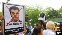 Turkey -- A Turkish protester holds a placard reading "Republic's women association" below a picture of German Bundestag member Cem Ozdemir, during a protest.