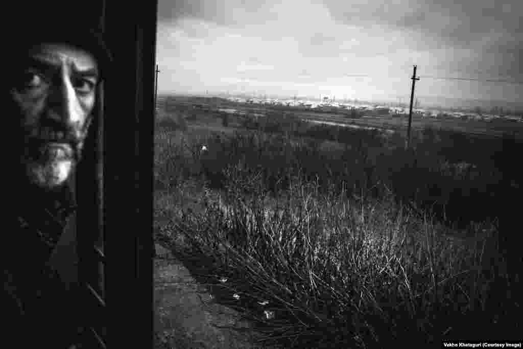 A passenger against the backdrop of a settlement for internally displaced persons, constructed after Russia's 2008 invasion of Georgia.