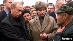 Ruski predsjednik Vladimir Putin rukuje se s neidentifikovanim rođakom člana posade, u prisustvu Irine Lajčin, supruge komandanta podmornice, u gradu Vidjajevo 22. avgusta 2000.