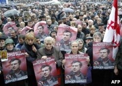 Supporters of the Georgian opposition hold portraits of opposition leader Mikheil Saakashvili during a protest outside the parliament in Tbilisi on November 10, 2003.