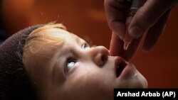 A health worker administers the polio vaccine to a child in Peshawar in December,