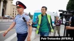 Radio Azattyq reporter Manas Kayirtauly tries to get a comment from a police officer in Almaty in 2019.