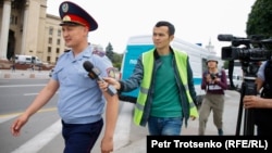 Manas Qaiyrtaiuly, a reporter for RFE/RL's Kazakh Service, attempts to speak to a police officer in Almaty in June 2019.
