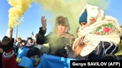 People hold flares in colors of the Ukrainian flag as they form a human chain on the bridge across the Dnieper River in Kyiv to mark the Day of Unity on January 22.