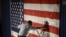 Hotel employee Denzil Telphia of Boston steams the wrinkles from an American flag hanging as a backdrop at the election night party for Democrat Elizabeth Warren, who won a seat in the U.S. Senate.