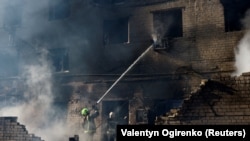 Пожежники працюють на місці російського дару у місті Бровари, Київська область, Україна, 14 березня 2026 року