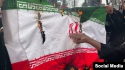 სტუდენტები ცეცხლს უკიდებენ ირანის ისლამური რესპუბლიკის დროშას საპროტესტო აქციაზე. 23 თებერვალი, 2026