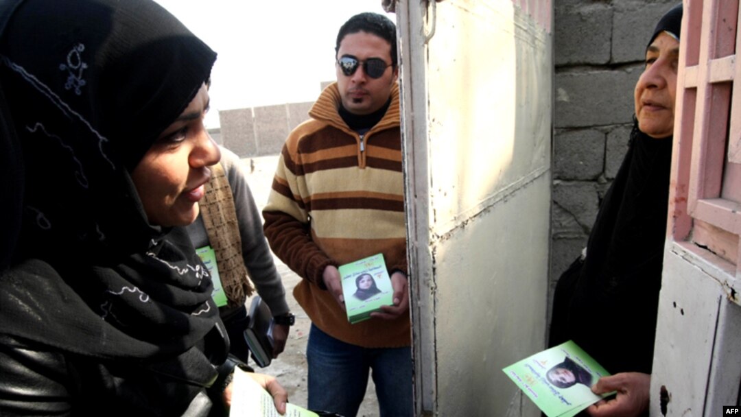 A female candidate from the National list, Zainab Sadiq Jaffer (left), campaigns in Al-Basrah.