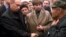Russian President Vladimir Putin (left) shakes hands with an unidentified relative of a crew member of the Kursk, as Irina Lyachin (center), the wife of the commander of the submarine, looks on, in the town of Vidyayevo on August 22, 2000.