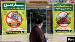 Large posters urge people to stay home and not travel in the city of Qom, a hotspot of coronavirus in Iran. March 28, 2020