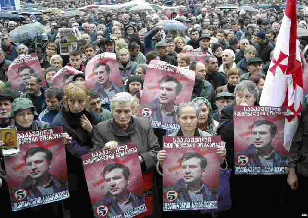 Georgian opposition demonstrators hold portraits of opposition leader Mikheil Saakashvili during a protest rally outside the Georgian parliament in Tbilisi on November 10.