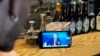 A bartender watches a live stream of Russian President Vladimir Putin's annual televised call-in show in a bar in Moscow on June 30.