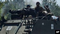 Soldați ucraineni pe un transportor blindat, pe linia frontului din regiunea Zaporojie, la 1 iulie, 