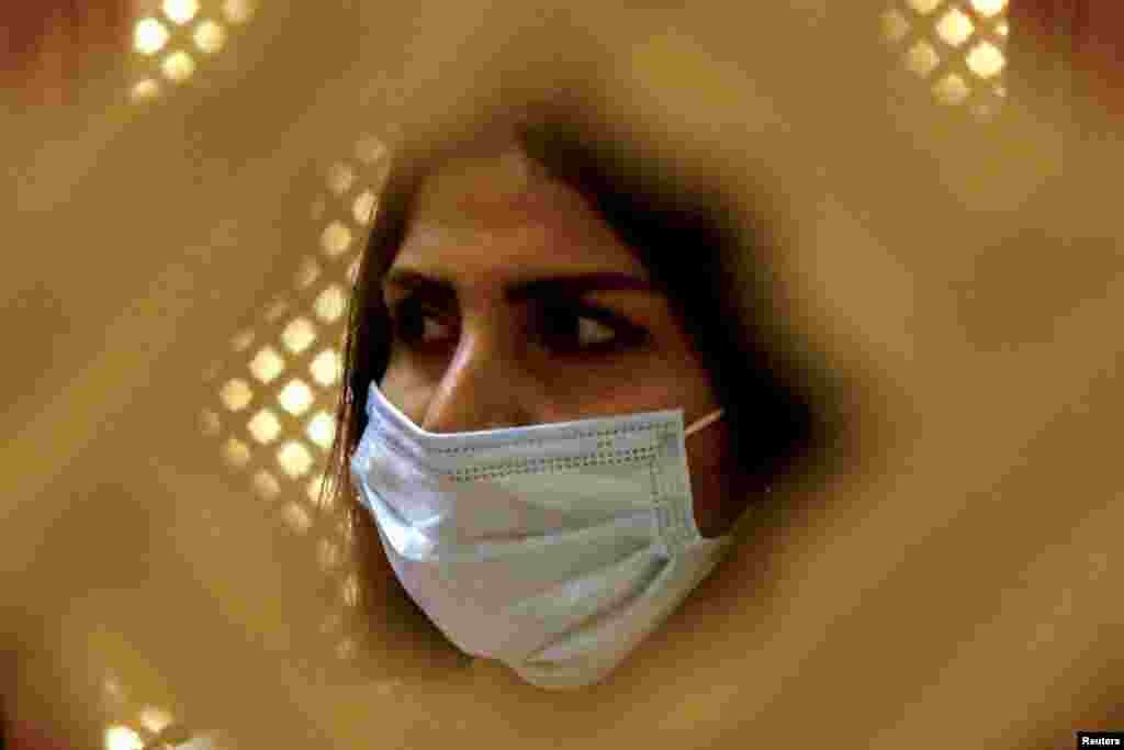 Një besimtare me maskë mbrojtëse kundër koronavirusit merr pjesë në meshën e Pashkëve në një kishë në Bagdad.&nbsp;​ 