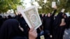 Disa gra duke mbajtur në duar kopje të Kuranit në Irak, për ta dënuar djegien e këtij libri.