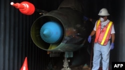 A man in Colon, Panama works in a container with a MiG-21 jet inside that was found on the North Korean vessel "Chong Chon Gang." 