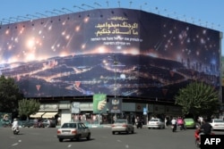 The Enqelab Square billboard, pictured in October 2024, depicting a rain of missiles striking Israel. The text includes a Farsi phrase "If you want war, we are the master of war."