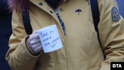 Човек държи чаша с надписа "Време е за истинска промяна".