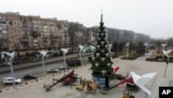 Na fotografiji: lokalni radnici postavljaju Novogodipnju jelku na trgu u Mariupolju, istočnom regionu Donjecka u Ukrajini koji kontrolišu ruske snage, 24. decembar 2022. 