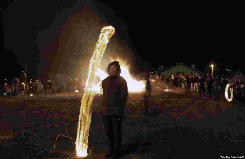 A long-exposure photo shows a Bulgarian child spinning a ball of fire near a bonfire during rituals in celebration of Mesni Zagovezni (Shrovetide) in the village of Lozen, near Sofia, on March 14. (AP/Valentina Petrova)