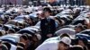 A police officer stands among Russian Muslims praying outside the central mosque in Moscow on July 5, 2016, during celebrations of Eid al-Fitr marking the end of the fasting month of Ramadan. / AFP PHOTO / KIRILL KUDRYAVTSEV