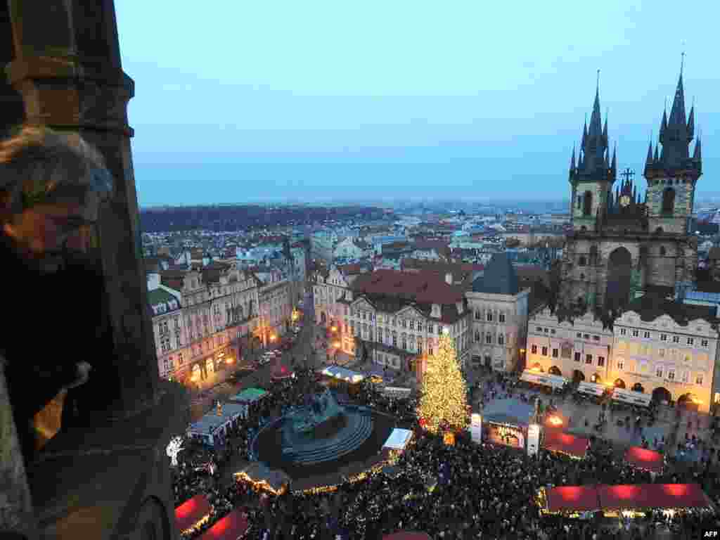 A man gazes down at the traditional Christmas market on the Old Town Square in Prague, Czech Republic. - Photo by AFP