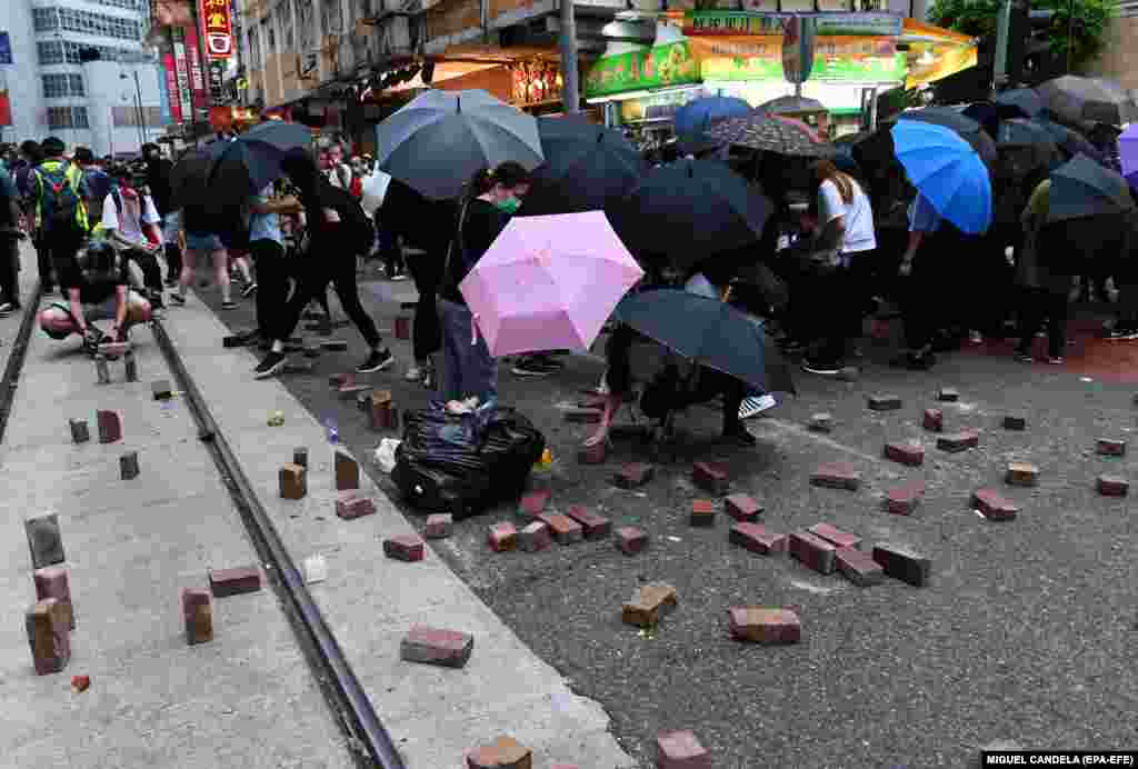 Протестувальники складають на дорогу цеглини під час протесту проти нового закону про нацбезпеку в Гонконгу, який передбачає, що підривну діяльність, сепаратизм, тероризм і співпрацю з іноземними силами каратимуть щонайменше 10 роками в&rsquo;язниці