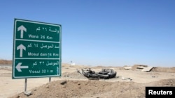 Iraq -- The wreckage of a car belonging to Islamic State militants lies along a road after it was targeted by a US air strike at the entrance to the Mosul Dam, northern Iraq, August 21, 2014