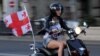 A supporter of the ruling United National Movement party rides a scooter in Tbilisi.